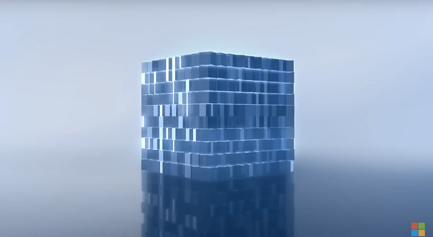 Topological quibit as a cube made up of multiple cubes on reflective surface in shades blue-gray.